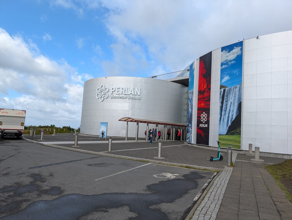 Entrance of Perlan, a museum in Iceland, featuring modern architecture and signage that reads 'Perlan Wonders of Iceland'.