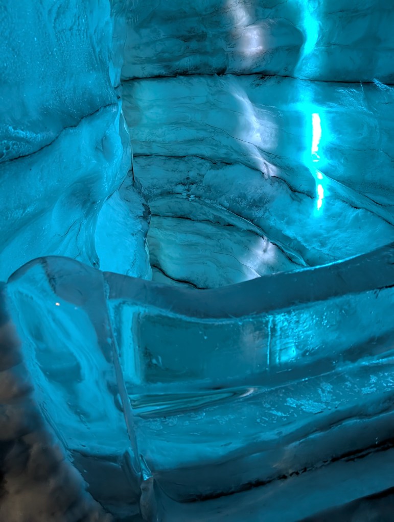 Close-up view of textured blue ice formations inside a glacier.